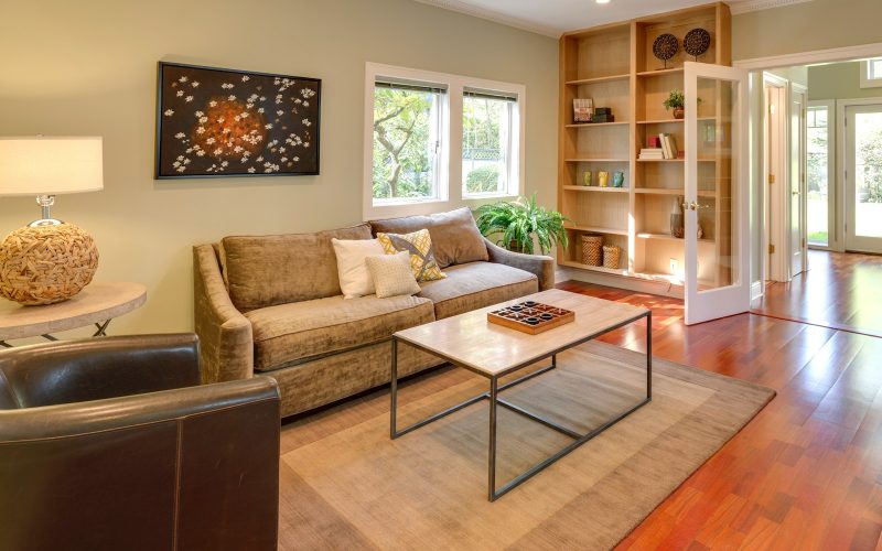 brown wooden table and couch with brown wooden bookshelf