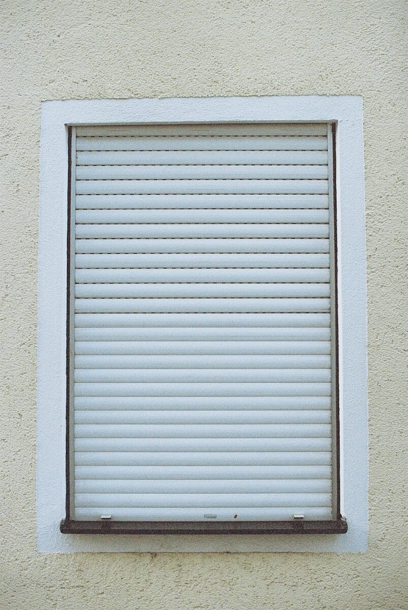 white window blinds on white concrete wall